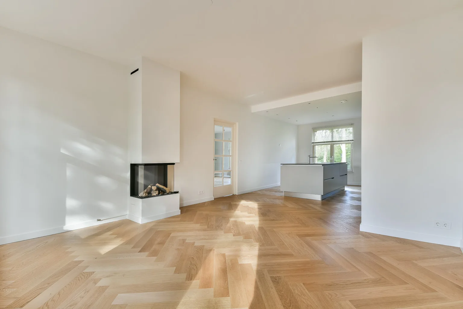 Licht Amsterdams appartement met visgraatvloer, haard en open keuken